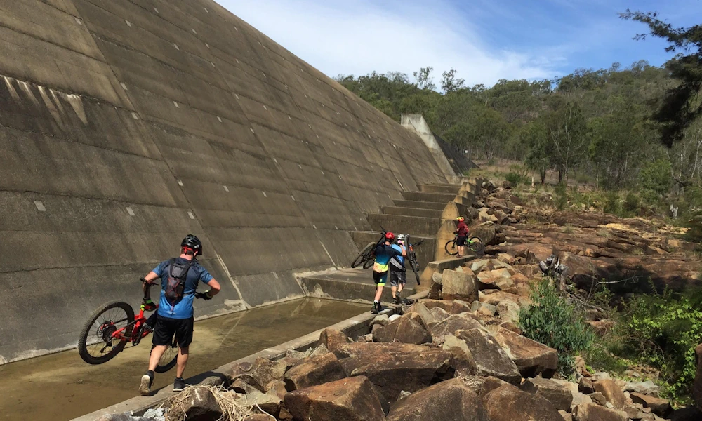 Skirting the wall of No. 7 Dam to reach the trails - Mount Morgan adventure ride 2018